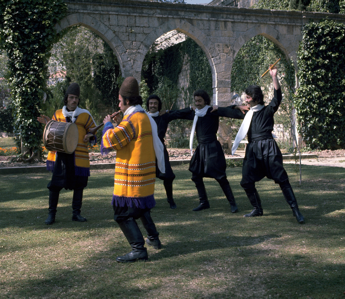 Dancers performing the dabke with a drummer and a flute player